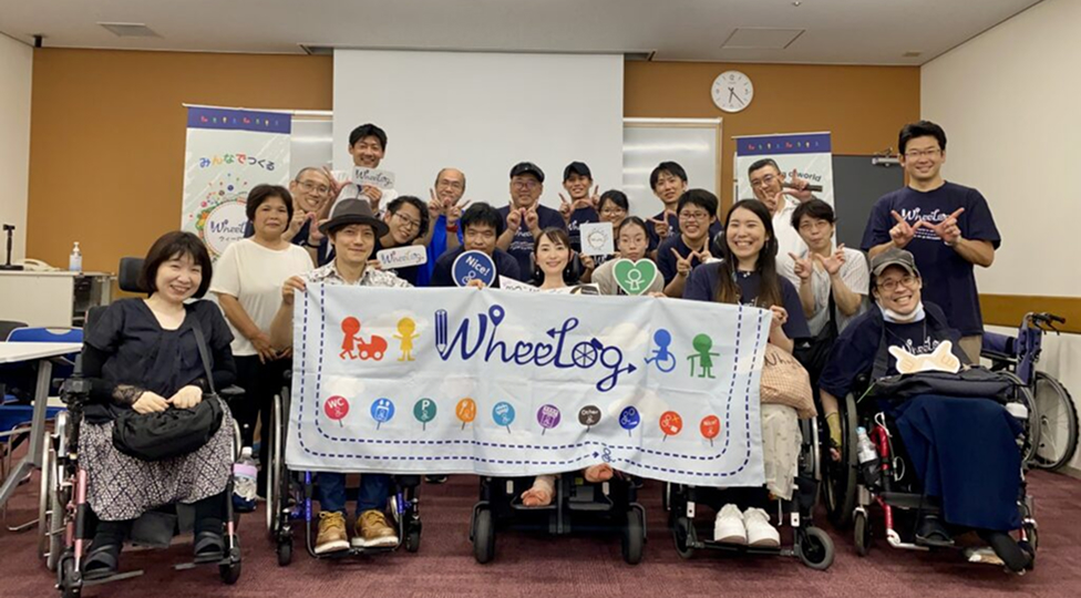 ボランティアイベントで車いすユーザーを含む参加者が集合写真に写る様子