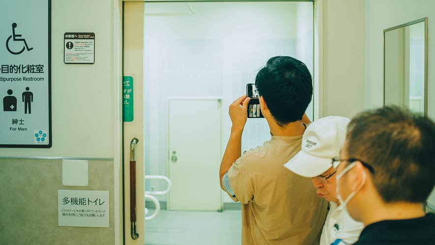 多機能トイレの案内表示をスマートフォンで撮影する参加者